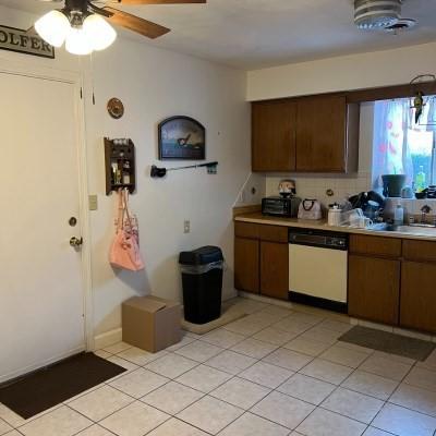 kitchen featuring sink, decorative backsplash, light tile patterned floors, ceiling fan, and white dishwasher