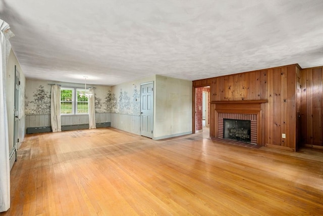 35 Chapin Rd, Holden, MA 01520 - unfurnished living room featuring light wood-type flooring, a brick fireplace, and a wainscoted wall