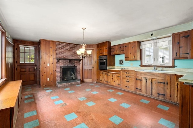 35 Chapin Rd, Holden, MA 01520 - kitchen featuring stainless steel oven, brown cabinetry, a sink, a chandelier, and wooden walls