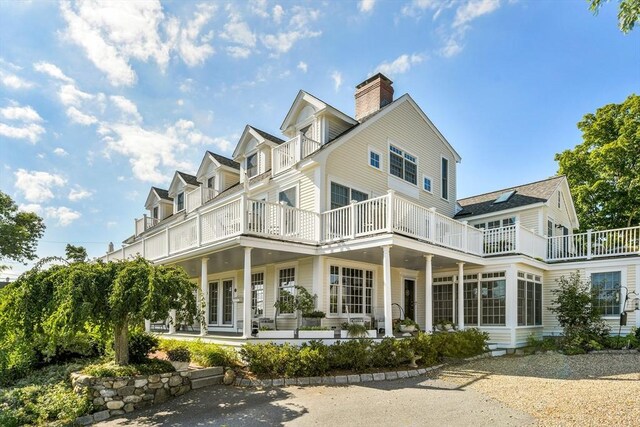 view of front of home with a balcony and a chimney