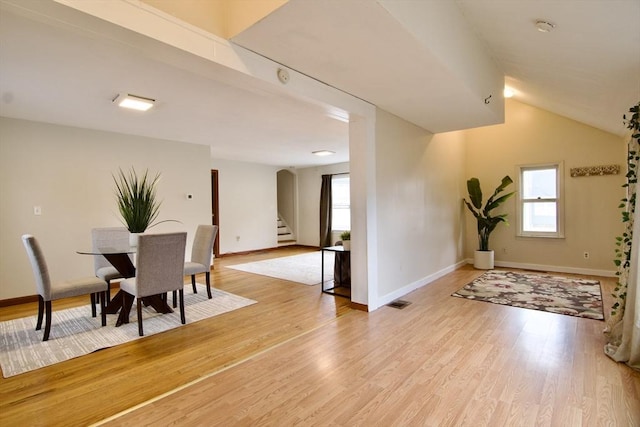 dining room featuring light wood-style floors, visible vents, stairway, and baseboards