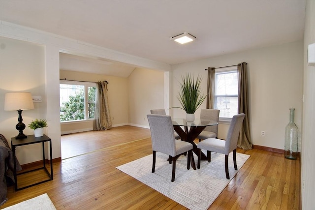 dining space featuring light wood-style flooring and baseboards