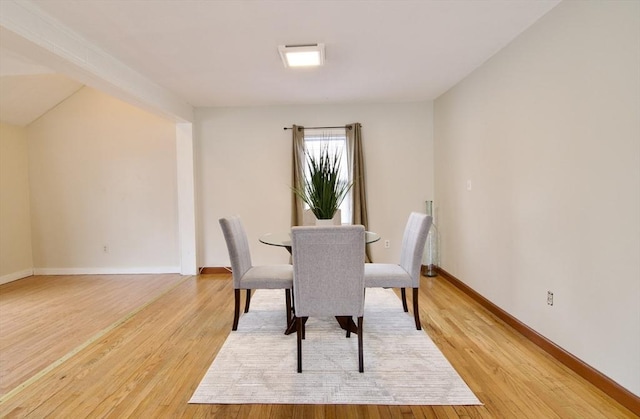 dining area with light wood-style floors and baseboards