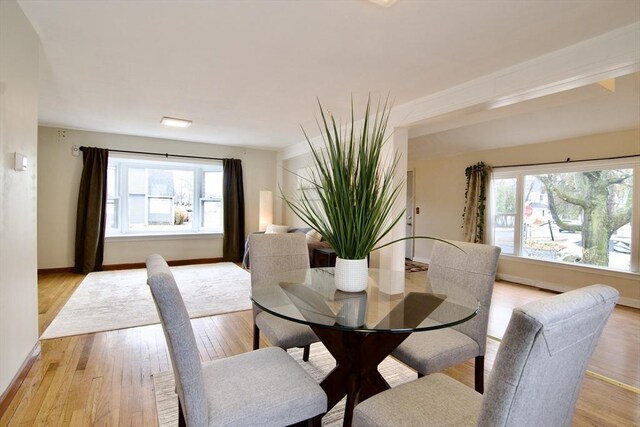 dining area with light wood-type flooring and baseboards