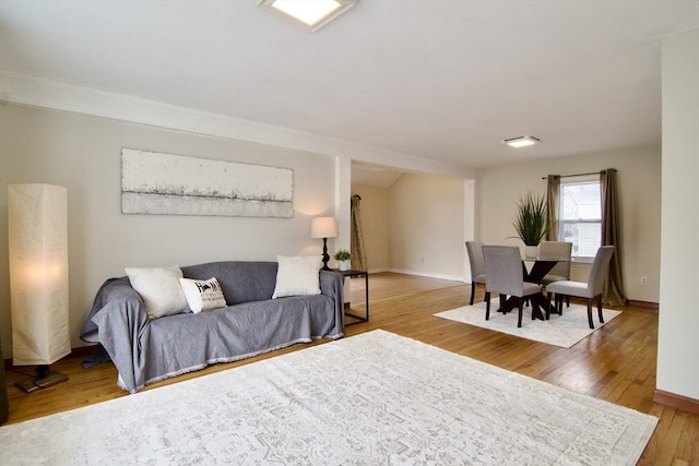 living area with wood-type flooring and baseboards