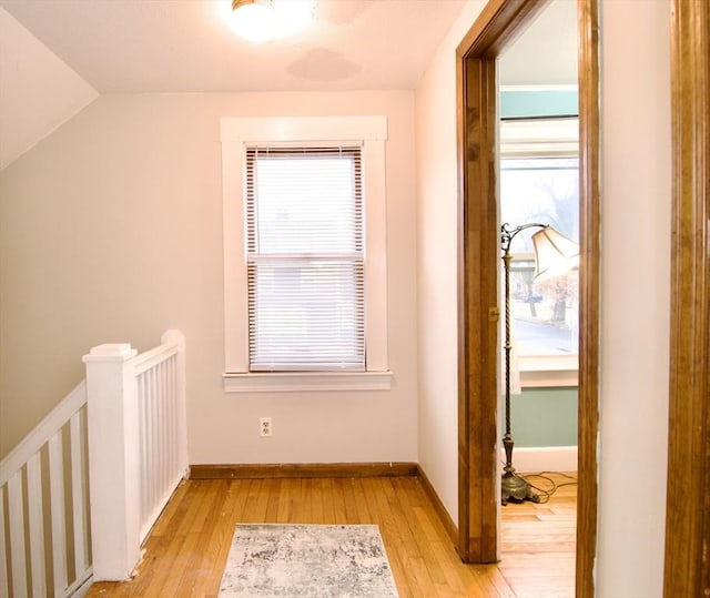 additional living space featuring lofted ceiling, light wood-style floors, and baseboards