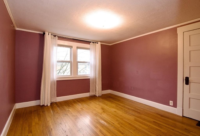 empty room with light wood-style flooring, baseboards, and crown molding