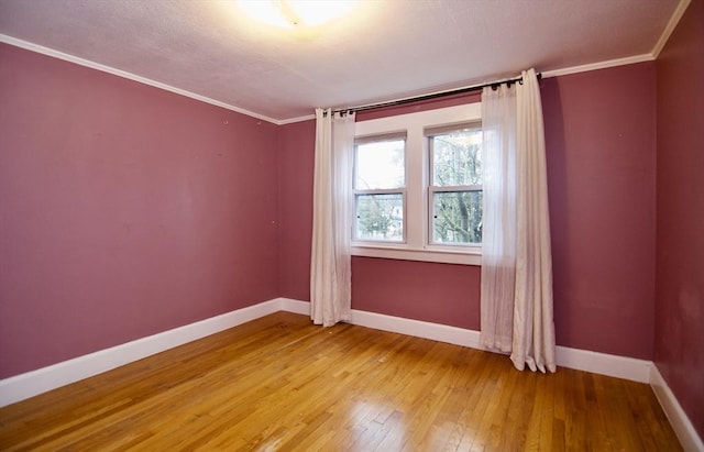 unfurnished room featuring ornamental molding, light wood-style flooring, and baseboards