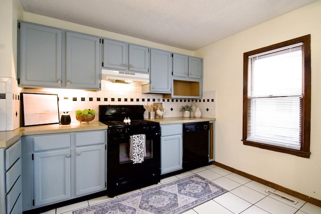 kitchen with under cabinet range hood, visible vents, light countertops, black appliances, and tasteful backsplash