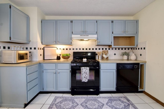 kitchen with black appliances, blue cabinets, light countertops, and under cabinet range hood