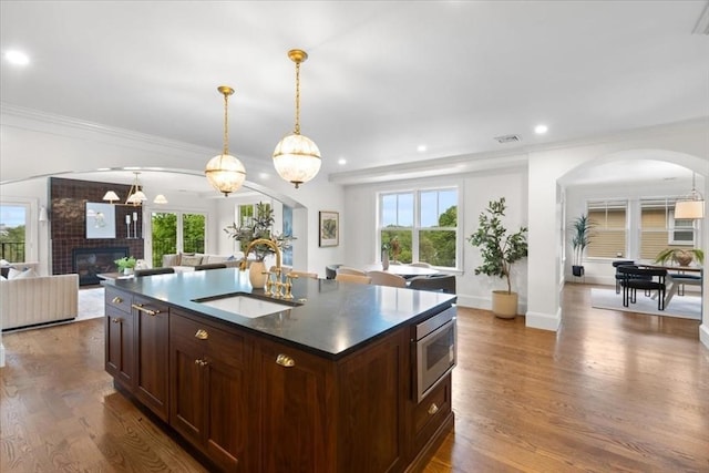 197 Winchester St Unit 197, Brookline, MA 02446 - kitchen with a sink, arched walkways, open floor plan, dark countertops, and stainless steel microwave