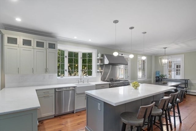 kitchen with stainless steel dishwasher, a kitchen island, a kitchen bar, a sink, and exhaust hood