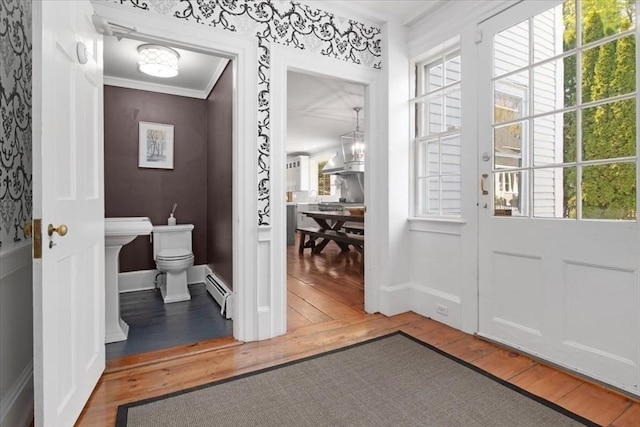 entryway featuring wood-type flooring, a baseboard heating unit, a notable chandelier, and plenty of natural light