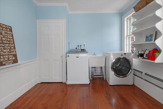 clothes washing area featuring crown molding, laundry area, separate washer and dryer, wood finished floors, and a baseboard radiator