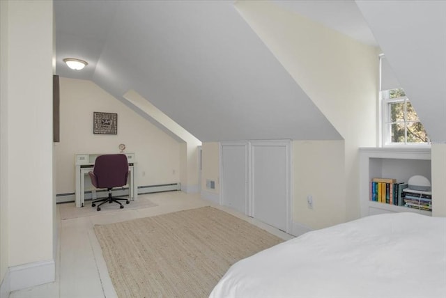 bedroom with a baseboard heating unit and lofted ceiling