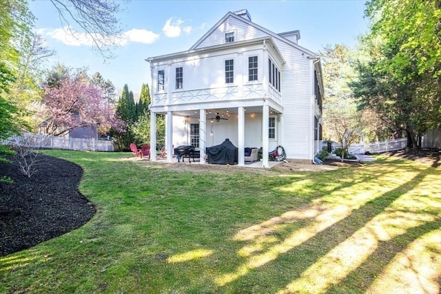 rear view of property featuring ceiling fan, stucco siding, a fenced backyard, a patio, and a yard
