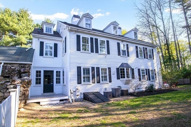 back of property with a lawn, a wooden deck, and cooling unit