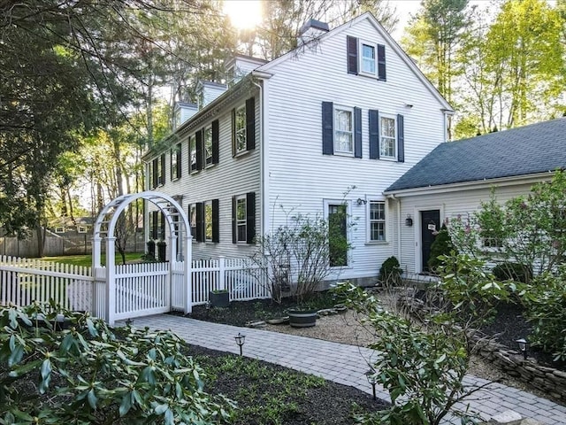 colonial home featuring fence and a chimney