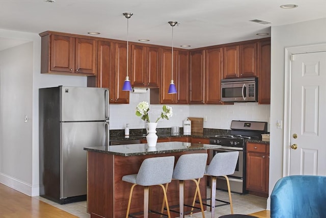 1306 Columbia Rd Unit 5C, Boston, MA 02127 - kitchen featuring tasteful backsplash, visible vents, appliances with stainless steel finishes, and a center island