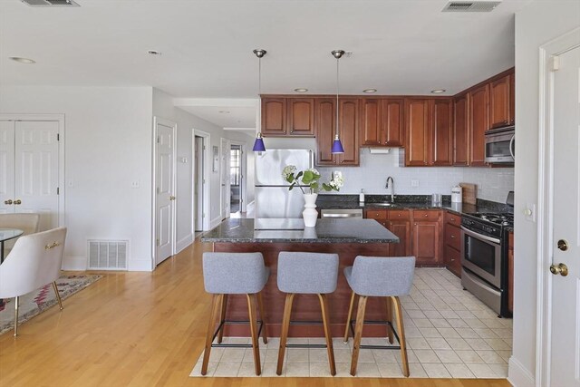 1306 Columbia Rd Unit 5C, Boston, MA 02127 - kitchen featuring visible vents, a sink, stainless steel appliances, tasteful backsplash, and a center island