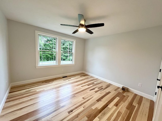 empty room featuring light wood-type flooring, baseboards, and ceiling fan