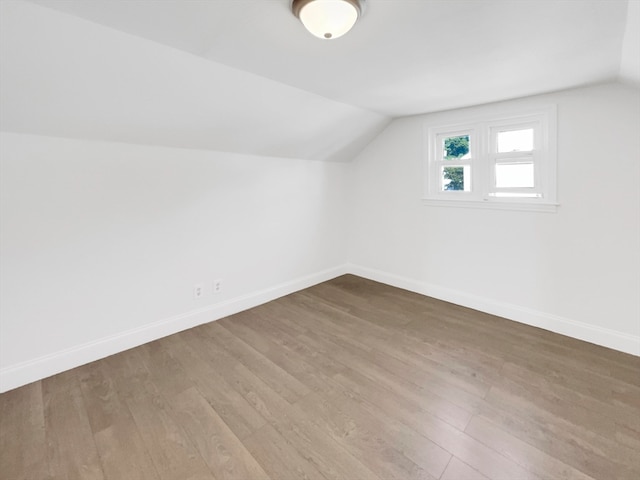 additional living space featuring lofted ceiling and hardwood / wood-style flooring