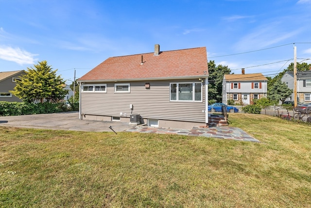 rear view of house with a yard, a patio, and central air condition unit