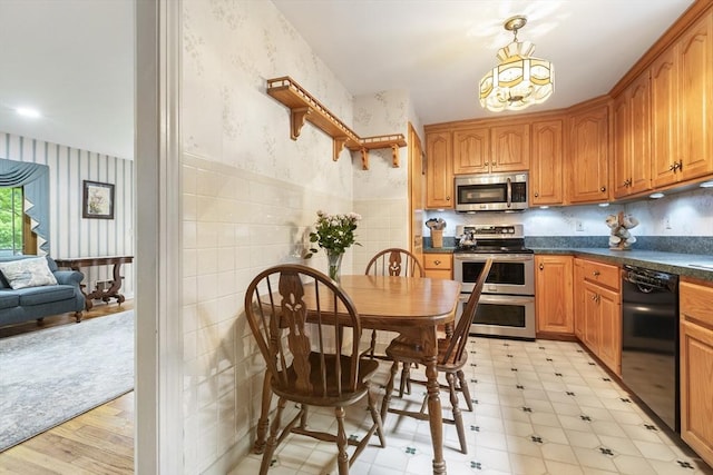 2 Rich Rd, Holliston, MA 01746 - kitchen with stainless steel appliances, wallpapered walls, dark countertops, a chandelier, and a wainscoted wall
