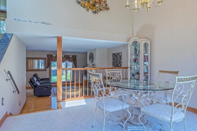 tiled dining space with baseboards and an inviting chandelier