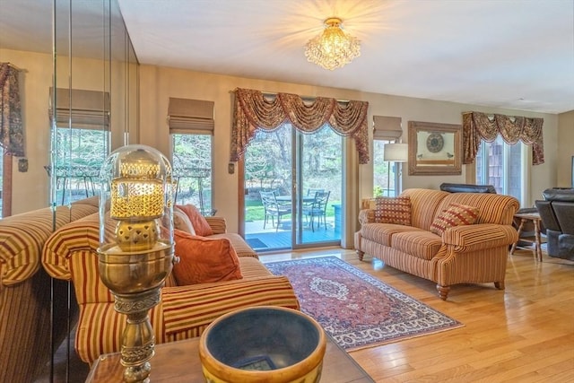 living room featuring plenty of natural light, wood finished floors, and a notable chandelier
