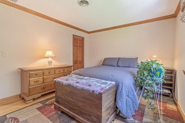 bedroom featuring crown molding, baseboards, visible vents, and light wood-style floors