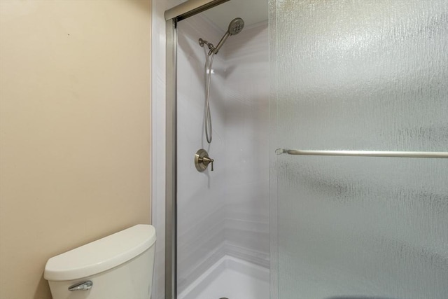 bathroom with toilet and a shower stall