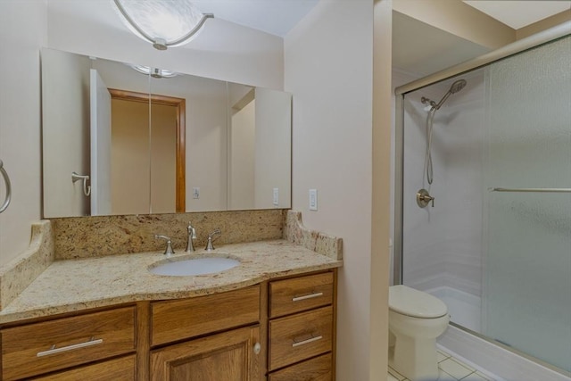 full bathroom featuring vanity, tile patterned flooring, toilet, and a shower stall