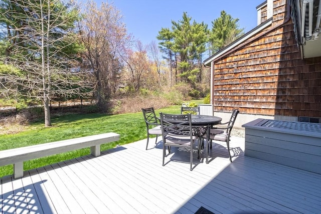 wooden terrace featuring a lawn and outdoor dining area