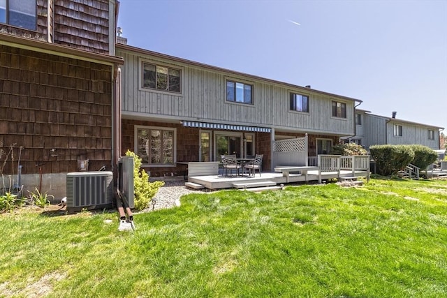 rear view of house featuring a lawn, central AC, a deck, and outdoor dining space