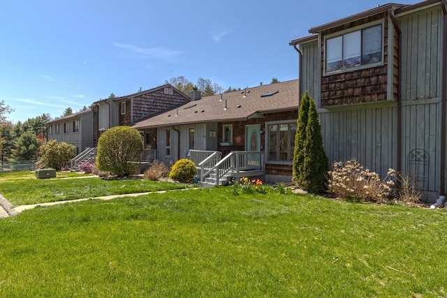 back of house with board and batten siding and a yard