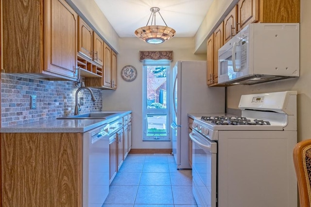 kitchen featuring light tile patterned flooring, a sink, white appliances, light countertops, and decorative backsplash