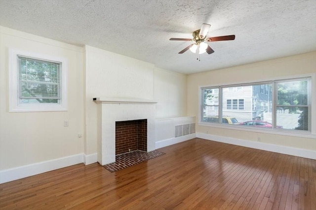 39-41 Arlington St, Methuen, MA 01844 - unfurnished living room featuring wood-type flooring, baseboards, ceiling fan, a textured ceiling, and a fireplace