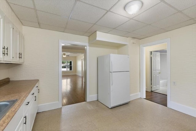 39-41 Arlington St, Methuen, MA 01844 - kitchen with freestanding refrigerator, baseboards, white cabinets, a drop ceiling, and a sink