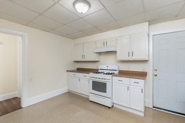 39-41 Arlington St, Methuen, MA 01844 - kitchen with white range with gas cooktop, under cabinet range hood, dark countertops, baseboards, and a paneled ceiling