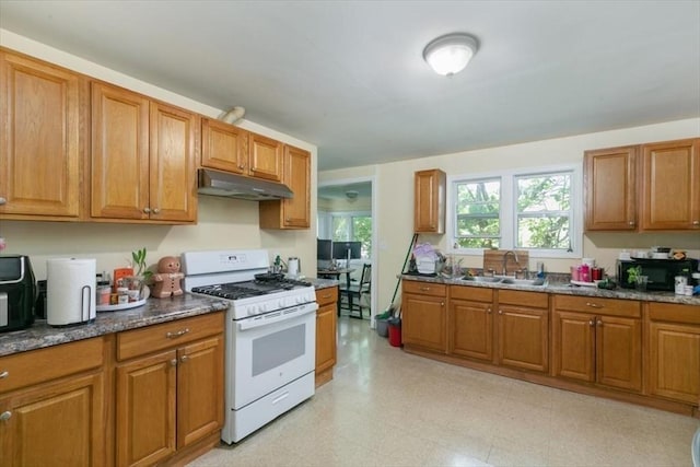 39-41 Arlington St, Methuen, MA 01844 - kitchen featuring white gas range, under cabinet range hood, a sink, and brown cabinetry