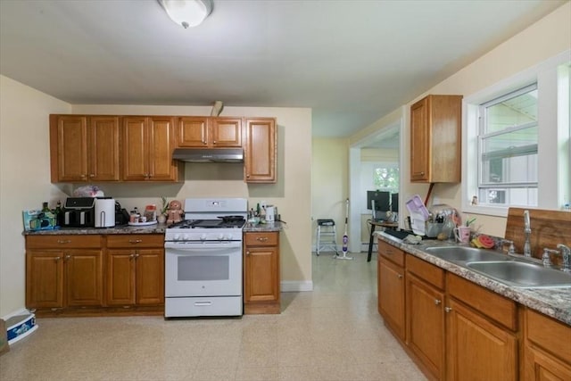 39-41 Arlington St, Methuen, MA 01844 - kitchen with white gas range oven, a sink, under cabinet range hood, and brown cabinets