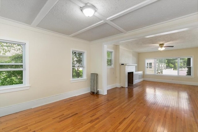 39-41 Arlington St, Methuen, MA 01844 - unfurnished living room featuring radiator, a textured ceiling, light wood-style floors, baseboards, and beam ceiling