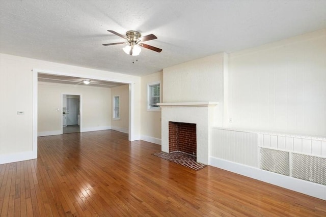 39-41 Arlington St, Methuen, MA 01844 - unfurnished living room featuring hardwood / wood-style floors, a ceiling fan, a fireplace with flush hearth, baseboards, and a textured ceiling