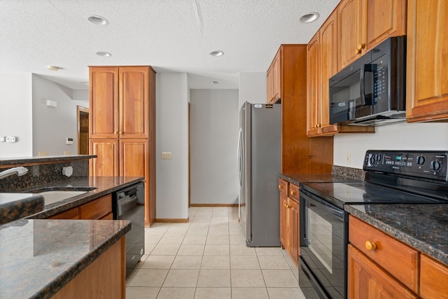 kitchen with light tile floors, a textured ceiling, black appliances, dark stone countertops, and sink