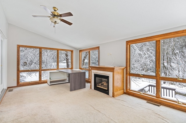 interior space featuring ceiling fan, vaulted ceiling, and light colored carpet