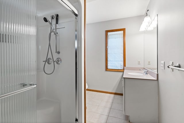 bathroom featuring a shower with shower door, toilet, tile floors, and vanity with extensive cabinet space