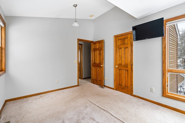 carpeted empty room with lofted ceiling