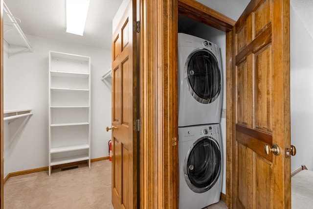 laundry room with stacked washer and clothes dryer and light carpet