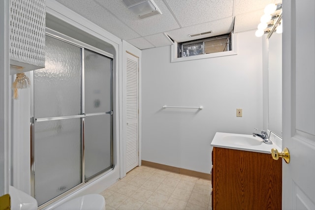 bathroom featuring toilet, tile floors, a drop ceiling, and large vanity